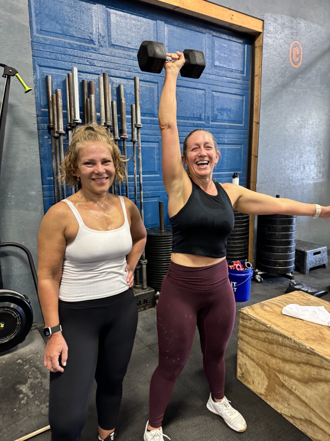 Member smiling while lifting a dumbbell overhead at Catoctin Fitness